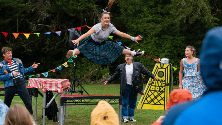 A woman in vintage costume performing outside in a park