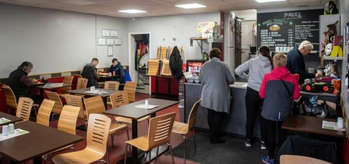 People queue at the counter in a community cafe.
